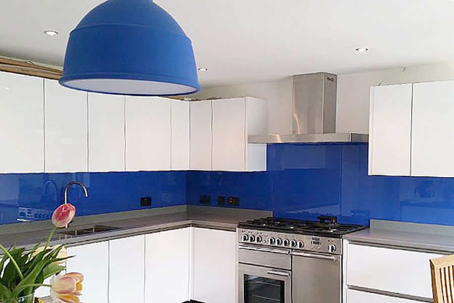Deep metallic blue glass kitchen splashback