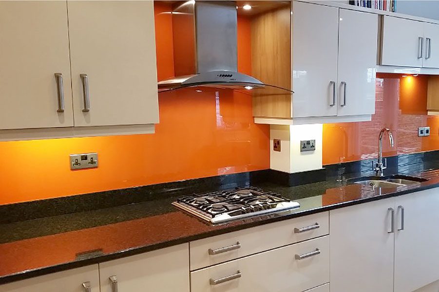 Orange painted glass kitchen splashback
