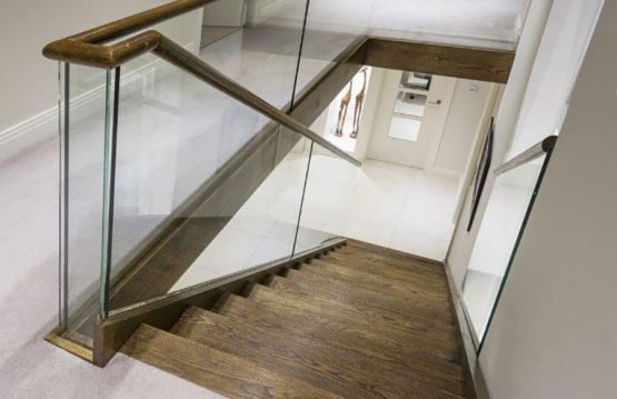 Glass staircase balustrade with dark oak steps
