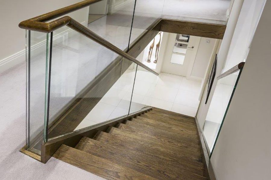 Glass staircase balustrade with dark oak steps