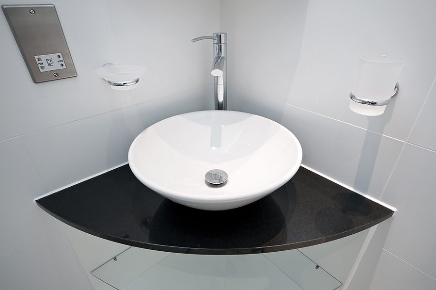 modern bowl style hand wash basin on a granite corner shelf