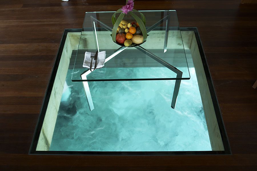 Decorative glass floor panel in a lounge with view to the sea below