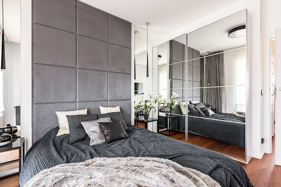 Mirrored wardrobe doors make this bedroom feel larger