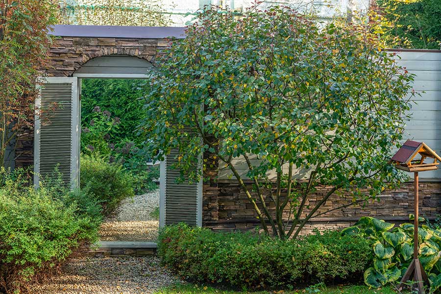 Garden mirror used to create the effect of another garden beyond a wall