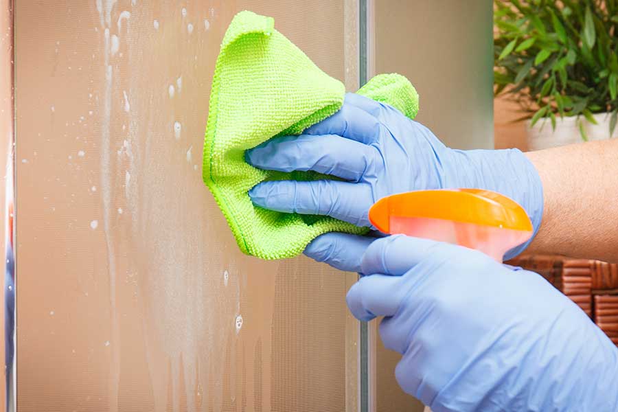 Spray and microfibre cloth used to clean shower glass