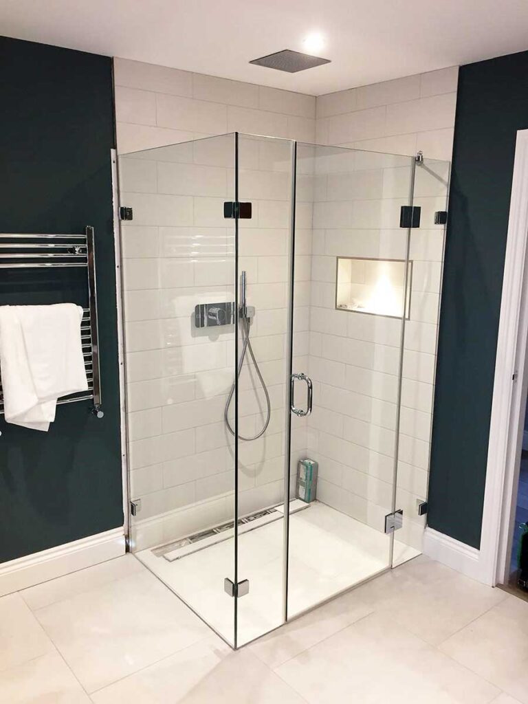 Large corner frameless shower enclosure with hinged door and side return panel in Cobham Surrey with glass produced by abc Glass Processing