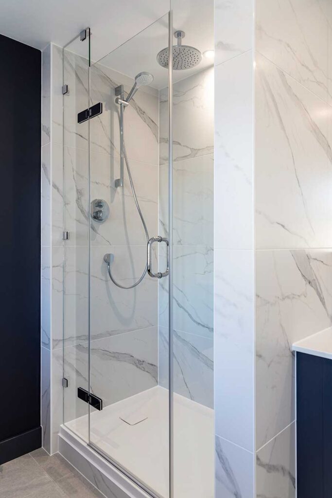 Frameless glass hinged shower door between two fixed glass panels in Pulborough West Sussex