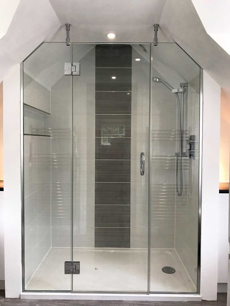 Angled bespoke loft shower with hinged door in Surrey